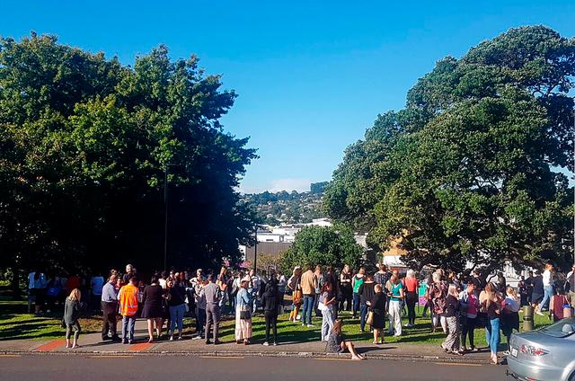 People gather on high ground in Whangarei, New Zealand, as a tsunami warning is issued