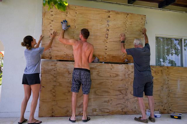 Residents cover the windows of their home in preparation for the arrival of Hurricane Beryl in Bridgetown, Barbados