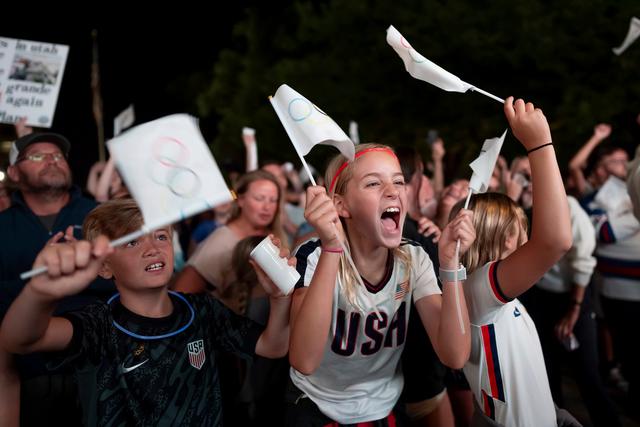 People celebrate while watching a live feed from Paris moments after the International Olympic Committee awarded Salt Lake City the 2034 Winter Olympics