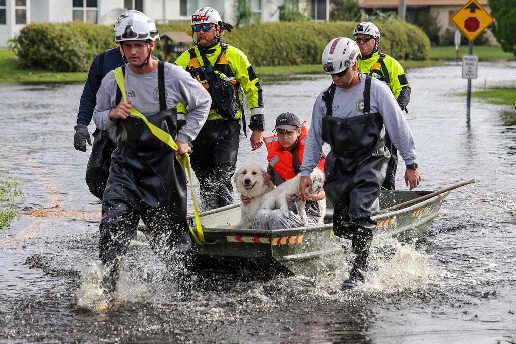 Amy Bishop is evacuated from her home by Pasco County Fire and Rescue and Sheriff's Office teams as waters rise in her neighborhood after Hurricane Milton caused the Anclote River to flood,