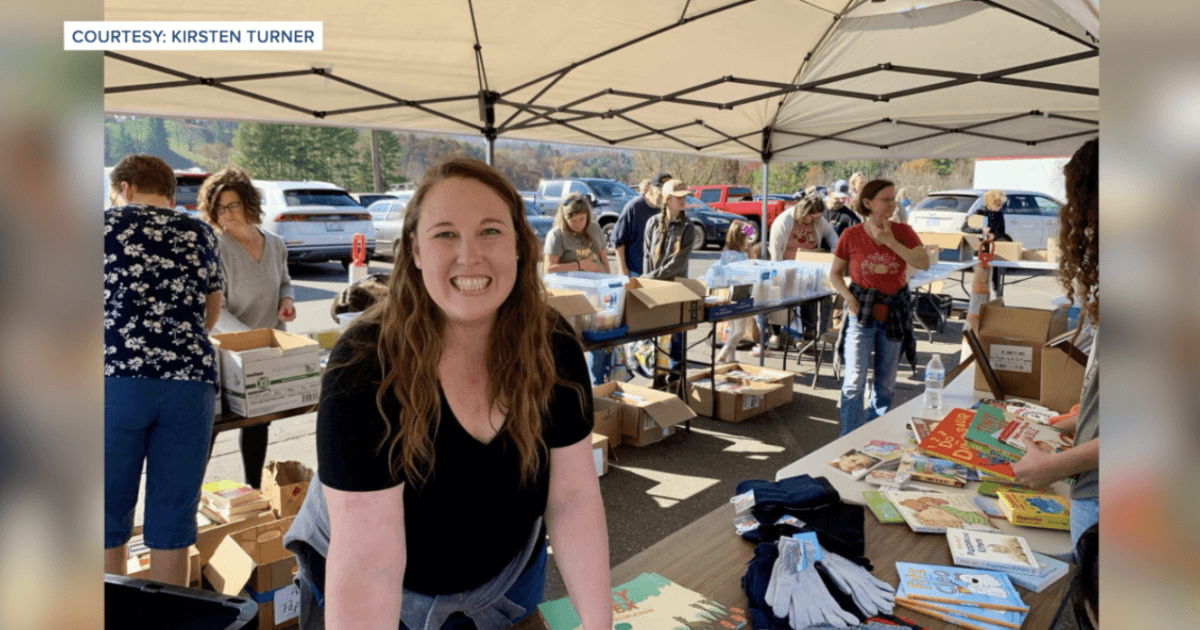 Woman smiling in front of tables full of books.